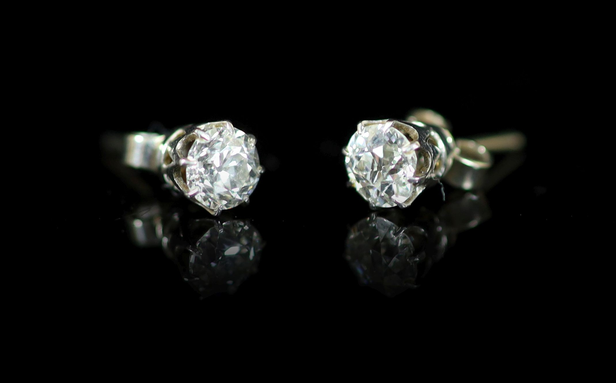 A pair of white gold and solitaire diamond ear studs